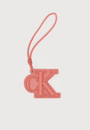 Porte-clés en cuir rose avec les lettres "cK" cousues et une boucle pour le porter.