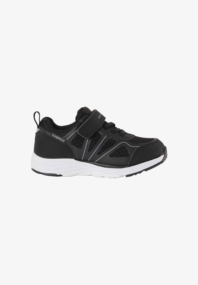 Chaussure de sport imperméable noire avec semelle blanche, mesh de ventilation, bandes réfléchissantes, bride à scratch et languette de traction au talon.