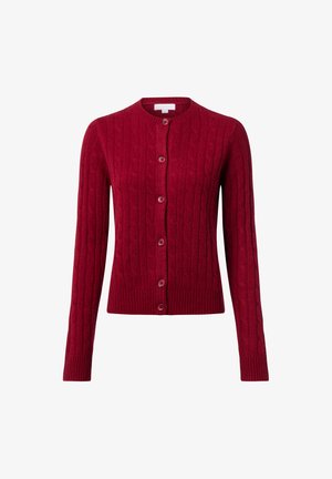 Czerwony sweter z plecionką, z okrągłym dekoltem, długimi rękawami i zapięciem na guziki z przodu. Posiada ściągacze przy rękawach i u dołu dla dodatkowej tekstury.