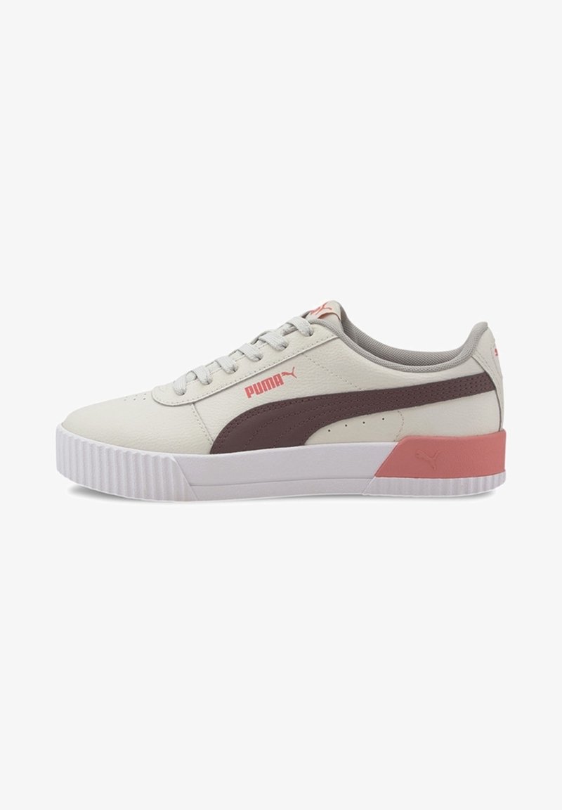 Baskets Puma en beige clair avec une bande marron, présentant un accent rose au talon, tige en cuir texturé et semelle en caoutchouc blanche.