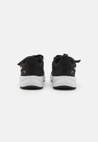 Baskets de sport noires avec une tige en tissu texturé, une semelle intermédiaire blanche et une semelle extérieure noire. Elles comprennent une languette et de petits accents de logo.