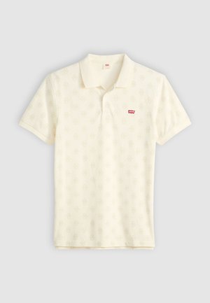 Krämfärgad polo t-shirt med en subtil helmönstrad design, korta ärmar, krage och en liten röd Levi's-logotyp på vänster bröst.