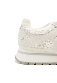 Sneaker bianco in suede con dettagli in pizzo, punta rotonda, suola ammortizzata con striscia grigia e dettaglio del logo sul lato.