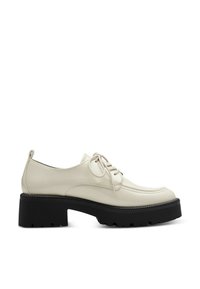 Beige leren schoen met een ronde neus, vetersluiting en een chunky zwarte plateauzool met een gestructureerd profiel.