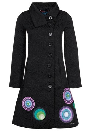 Mustassa pitkähihaisessa teksturoidussa takissa on suuret napit ja värikkäitä pyöreitä kuvioita helman lähellä edessä.