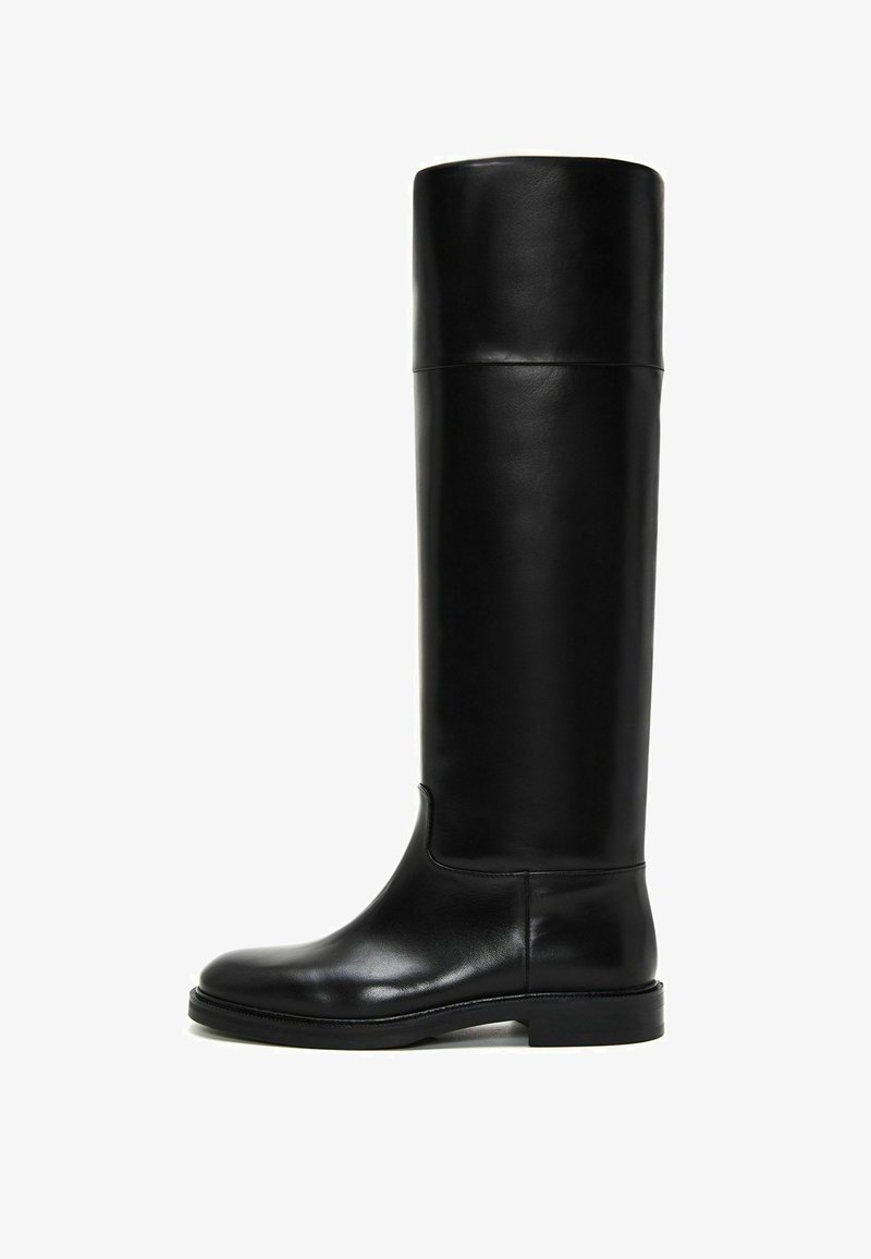 Bota de cuero negro hasta la rodilla con punta redonda, textura suave, diseño minimalista y suela de goma plana. Sin herrajes ni patrones visibles.