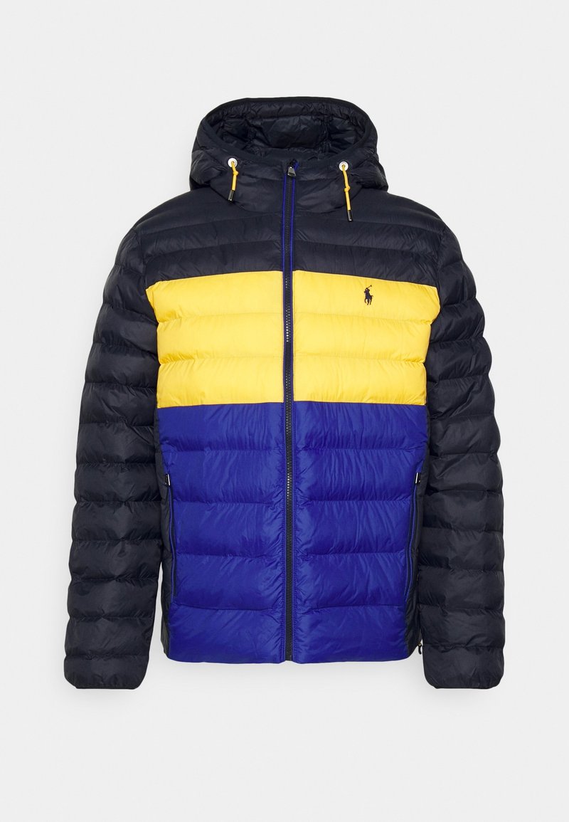 Puffjacka med huva, horisontella färgblock i gult, blått och svart, med dragkedja hela vägen fram och logotyp på bröstet.