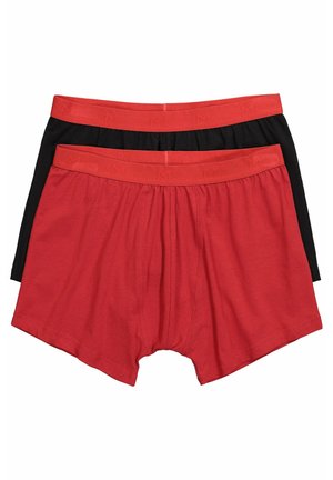 Dwie pary męskich bokserek, jedna czerwona i jedna czarna, obie z pasującymi czerwonymi elastycznymi paskami w talii.