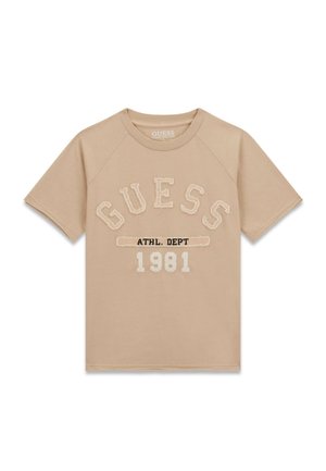 Beiges T-Shirt mit kurzen Ärmeln, vorne mit großem "GUESS" Schriftzug, kleinerem Text "ATHL. DEPT" und darunter der Jahreszahl "1981" bedruckt.