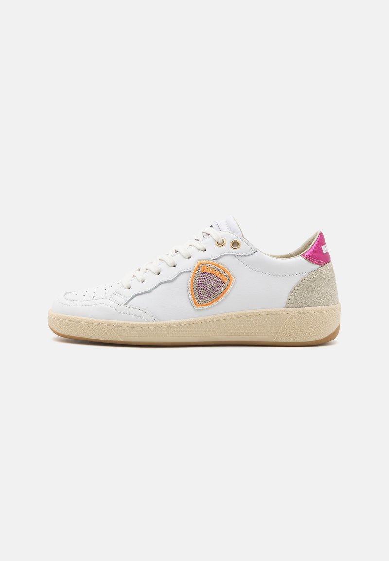 White leather sneaker with perforated toe, orange and pink emblem, beige textured sole, and contrasting pink heel tab.
