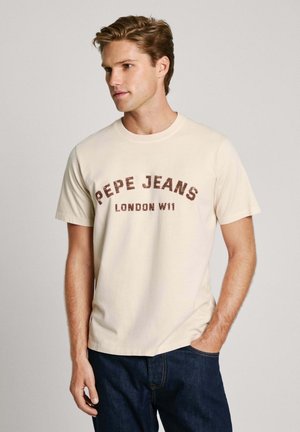 Beige bomulds t-shirt med rund hals og korte ærmer, med teksten "PEPE JEANS LONDON W11" trykt i mørkebrun over forsiden.