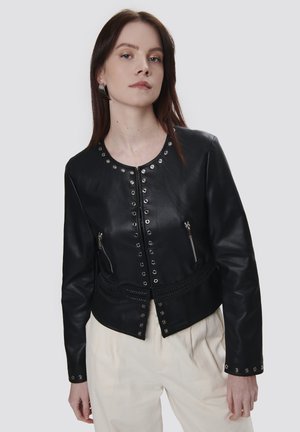 Giacca in pelle nera con bottoni a pressione e zip in argento, caratterizzata da una silhouette strutturata, colletto rotondo e vita testurizzata.
