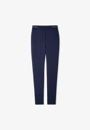 Pantalones azul marino ajustados con frente plano y cintura elástica que presenta detalles sutiles de rayas blancas.