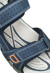 Sandalo blu con cinturini perforati, cuciture bianche e accentuazione arancione. La soletta strutturata presenta un motivo a onde per una maggiore aderenza e comfort.