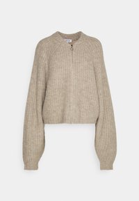 Beige gebreide cropped cardigan met ribbelstructuur, rits vooraan, ronde halslijn en volumineuze mouwen. Eenvoudig ontwerp zonder extra patronen.