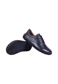 Chaussures décontractées en cuir noir à lacets avec semelles en caoutchouc, l'une montrant le dessus et l'autre le motif de la semelle dessous.