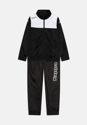 Melnas sporta uzvalks ar baltām akcentiem. Aizdaramā jaka ar stāvu apkakli; biksēm gar kāju ir logo druka. Gluda tekstūra.