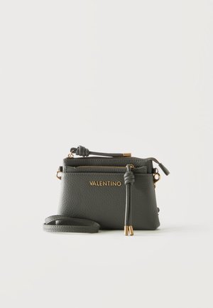 Väike must Valentino crossbody käekott kuldse logoga, lukuga, reguleeritava rihmaga ning dekoratiivsete sõlmitud nahast narmastega valgel taustal.