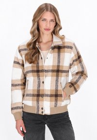 Ruudullinen takki beigen, ruskean ja valkoisen sävyissä. Valmistettu pehmeästä kankaasta, jossa on napit ja sivutaskut. Varren ja helman ribbireunukset.