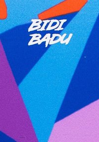 Patroontextiel met gedurfde geometrische vormen in blauw, paars en oranje. Het ontwerp bevat de tekst "BIDI BADU" in een wit, speels lettertype.