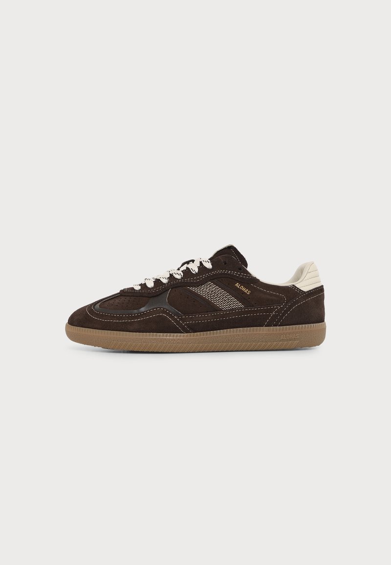 Baskets en daim marron foncé avec lacets blancs, accent beige au talon, semelle en gomme et logo ALOHAS sur le côté.