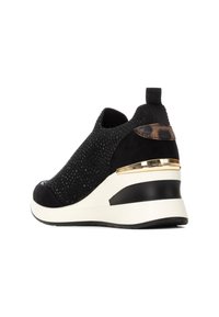 Zapatillas cuña de punto negro con detalles de ante, detalle en oro en el talón, parte superior texturizada y puntera redondeada. Diseño sin cordones con tirador.