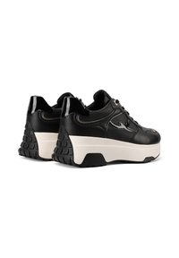 Sneaker in pelle nera con suola piattaforma bianca spessa, tacco in gomma nera testurizzata e sottili dettagli di design sui lati.