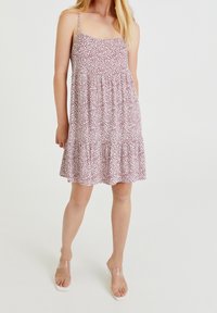 Robe d'été à imprimé floral avec bretelles spaghetti ajustables, coupe ample et ourlet à volants étagés en couleurs rose et blanc.
