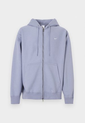 Light purple zip-up hoodie made of soft fabric, featuring a full zipper, two front pockets, and a small white logo on the left chest.