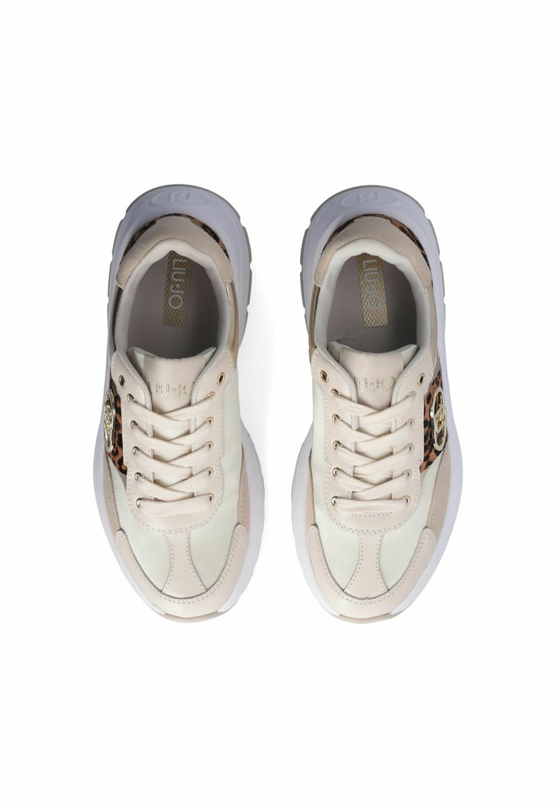 Zapatillas de deporte de color beige claro con un upper texturizado, diseño de cordones, suela de goma blanca y detalles de print de leopardo en el lateral. Presencia de un logotipo dorado.