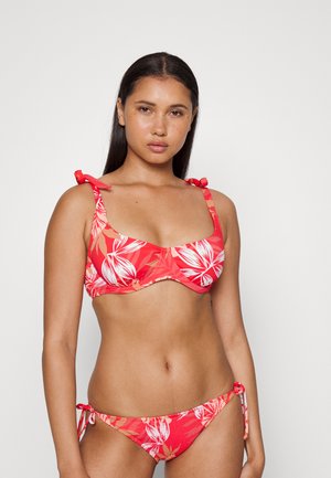 Conjunto de biquíni floral vermelho com copas almofadadas, alças ajustáveis e parte de baixo combinando com laços laterais. O material tem uma textura suave.