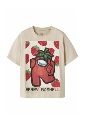 T-shirt beige à manches courtes avec un personnage rouge de dessin animé portant un haut fraise, entouré de fraises, avec le texte « BERRY BASHFUL » en dessous.