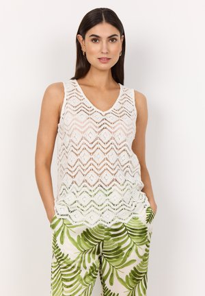 White sleeveless top with a V-neck and zigzag crochet pattern. Paired with green leaf-patterned pants; casual design includes side pockets.