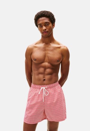 Pantaloni da bagno rossi con motivo e vita regolabile. Materiale leggero, lunghezza al ginocchio, caratterizzati da un design geometrico in colori a contrasto.