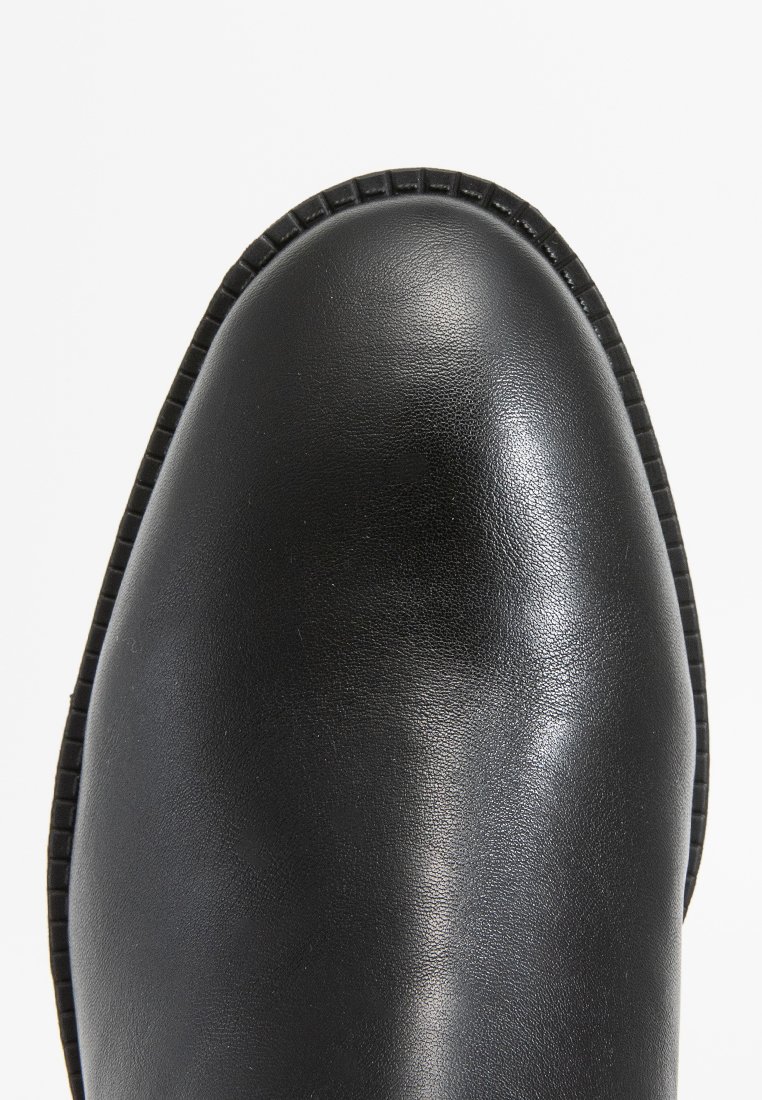 Schwarze Leder-Ankle-Boots mit runder Zehenform, strukturierten Oberflächen und sichtbaren Nähten entlang der Sohle für zusätzliche Details.