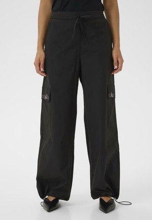 Schwarze Cargo-Hosen mit elastischem Bund, Kordelzugverschluss und Seitentaschen. Sie verfügen über einen lockeren Schnitt und Reißverschlussakzente an den Knöcheln.