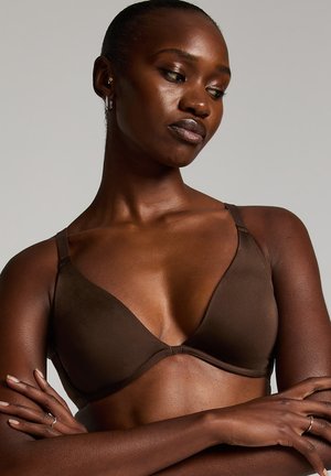 Bra in Braun mit Polsterung, kabellos, verstellbaren Trägern, dreieckigen Cups, glattem Stoff und minimalistischem Design. Die weiche Textur betont den Komfort.