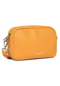 Sac bandoulière en cuir jaune avec une texture tissée, fermeture zip et sangle réglable. Présente le logo de la marque sur le devant.