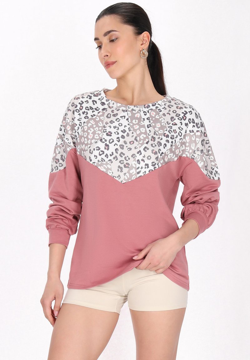 Leopárdmintás pulóver, rózsaszín alsó résszel, puha anyagból, hosszú ujjakkal és kerek nyakkivágással. Elasztikus mandzsettákkal és chevron mintával rendelkezik.