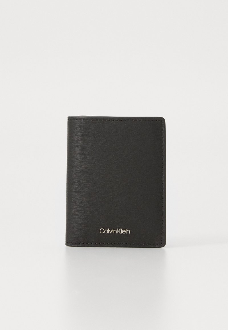 Black leather wallet with a textured finish, bi-fold design, featuring a gold logo on the lower front. Minimalist and sleek appearance.