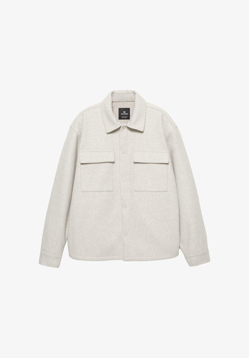 Vaaleanharmaa sherpa-takki napilla edessä, kahdella rintataskulla ja klassisella kauluksella. Pehmeä kangas ja rento istuvuus.