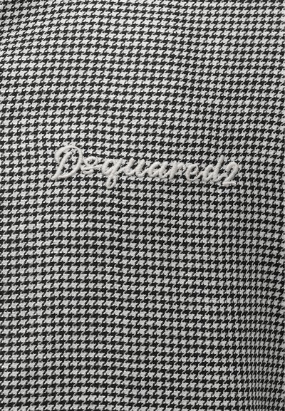 Ύφασμα σε ασπρόμαυρο σχέδιο χοντρού ψαροκόκκαλου με το λευκό κεντημένο λογότυπο "Dsquared2" στο κέντρο της υφασμάτινης επιφάνειας.