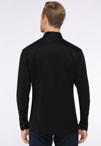 Schwarzes langärmliges Hemd aus glattem Stoff, mit einem klassischen Kragen und geknöpften Manschetten, geradem Saum und ohne sichtbare Muster.