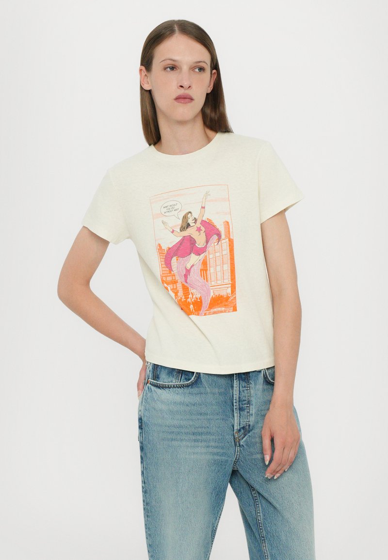 Cremfarbendes Kurzarm-T-Shirt mit einem Comic-ähnlichen Grafikmotiv einer Frau in einem pinken Umhang. Lässige Passform, aus weichem Baumwoll-Mix-Stoff gefertigt.