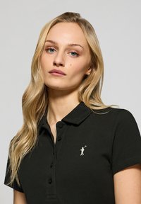 Czarna koszulka polo z kołnierzykiem, z logo golfisty. Krótkie rękawy i zapięcie na guziki z teksturowanym wykończeniem.