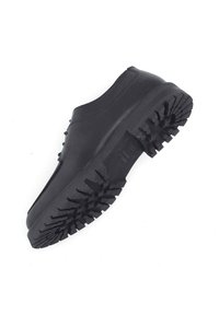 Chaussure en caoutchouc noir avec un design arrondi, semelle épaisse et un motif de semelle texturé et rugueux pour une meilleure adhérence. Surface supérieure lisse.