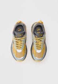 Gule og grå mesh sneakers med polstret tunge, snøring, gummisåle og reflekterende detaljer. Har et intrikat mesh-mønster.