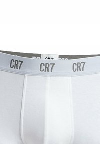 Boxer in cotone bianco con elastico grigio, caratterizzato da una ripetizione del marchio "CR7" in lettering nero. Texture liscia, vestibilità standard.