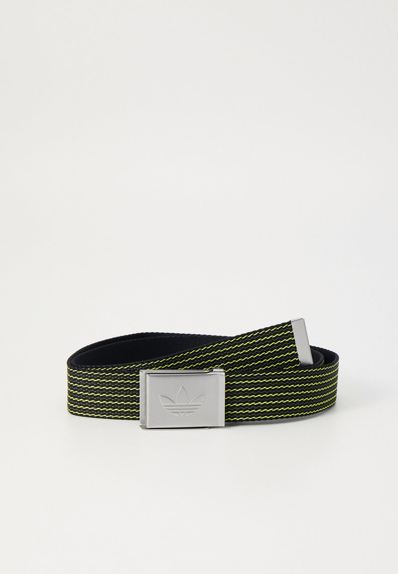 Austa melna josta ar zaļām un dzeltenām svītrām, kas aprīkota ar kvadrātveida sudraba metāla sprādzi ar iegravētu logo. Regulējama garuma.