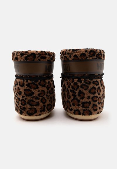Ζεύγος καφέ και μαύρων χνουδωτών παντόφλων με λεοπάρ σχέδιο, με χοντρή επένδυση και στρογγυλή μύτη, από πίσω σε λευκό φόντο.